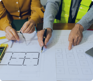 Two architects reviewing building blueprints and planning construction project during consultation session