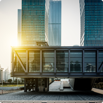 Futuristic glass skybridge connecting two modern skyscrapers in an urban cityscape under a clear sky