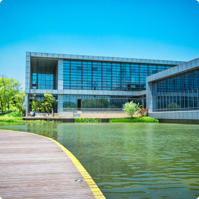 Modern office building near a waterfront with contemporary architecture and city skyline in the background